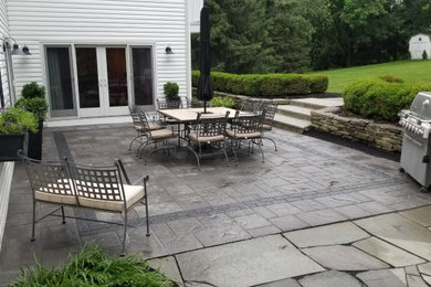 Example of a mid-sized classic backyard concrete paver patio design in Philadelphia with no cover