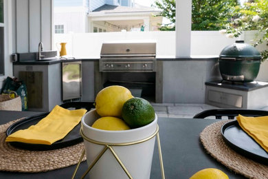 Patio kitchen - mid-sized contemporary backyard concrete paver patio kitchen idea in Jacksonville with a roof extension