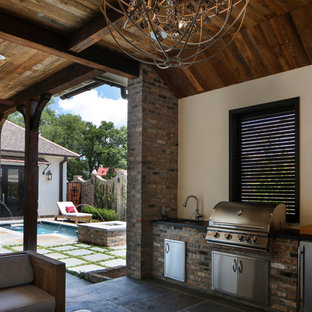 Mid-sized transitional courtyard stone patio kitchen photo in New Orleans with a roof extension