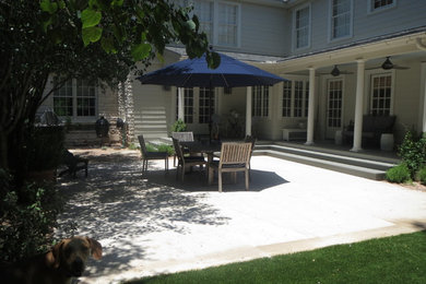 Example of a large minimalist backyard concrete paver patio kitchen design in Austin with no cover