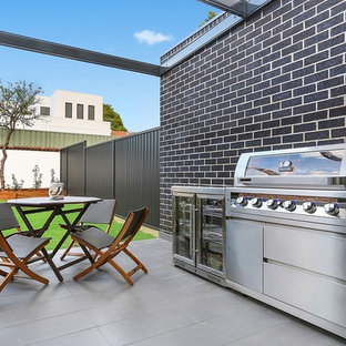 Photo of a contemporary backyard patio in Sydney with tile and a pergola.