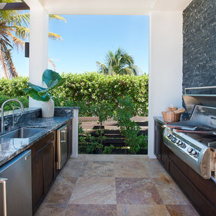 Diseño de patio tropical con cocina exterior y pérgola