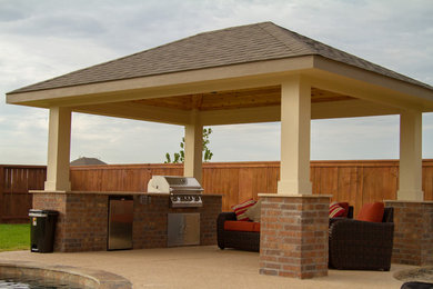 Foto di un patio o portico classico di medie dimensioni e dietro casa con pavimentazioni in pietra naturale e un gazebo o capanno