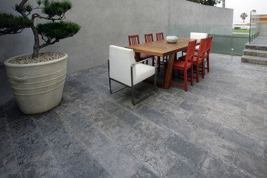 Imagen de patio actual grande sin cubierta en patio trasero con adoquines de piedra natural