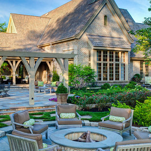 Elegant backyard patio photo in Chicago with a fire pit and a pergola