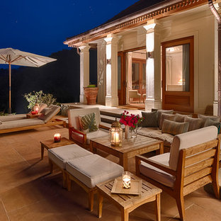 Inspiration for a medium sized world-inspired back patio in Hertfordshire with natural stone paving and an awning.