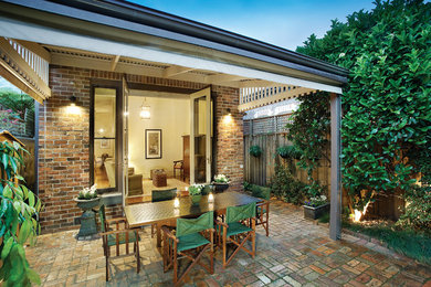 Idee per un piccolo patio o portico boho chic dietro casa con pavimentazioni in mattoni e una pergola