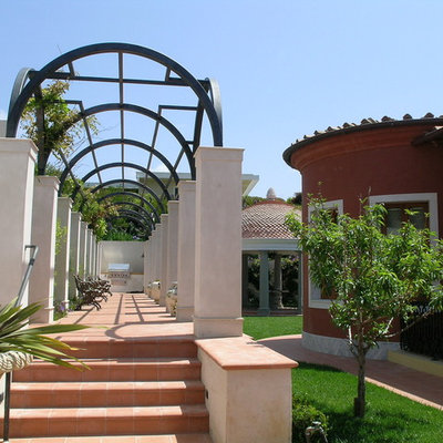 Example of a tuscan tile patio design in Orange County with a pergola