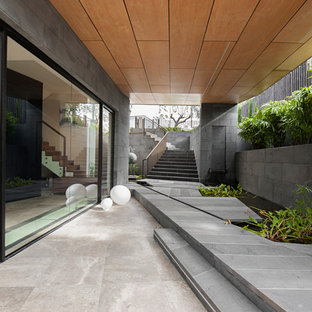 Inspiration for a contemporary patio in Sydney with a water feature, tile and a roof extension.