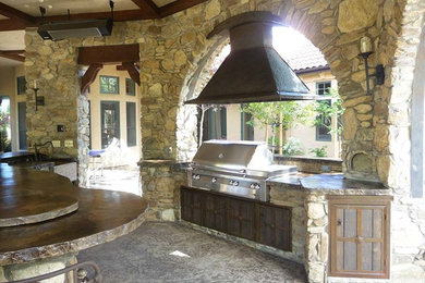 Imagen de patio clásico grande en patio trasero y anexo de casas con cocina exterior y adoquines de piedra natural
