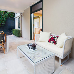 Idee per un patio o portico vittoriano di medie dimensioni e dietro casa con pavimentazioni in pietra naturale e un tetto a sbalzo
