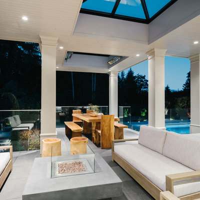 Large transitional backyard tile patio photo in Vancouver with a roof extension and a fire pit