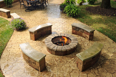 Example of a large classic backyard stamped concrete patio kitchen design in Other with no cover