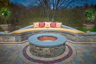 Example of a mid-sized classic backyard stone patio design in Boston with a fire pit and no cover