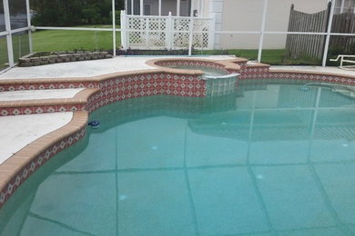 Ejemplo de piscina con fuente minimalista grande en patio trasero con adoquines de hormigón
