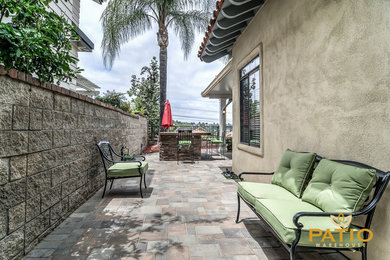 Esempio di un grande patio o portico minimalista dietro casa con pavimentazioni in cemento e un parasole