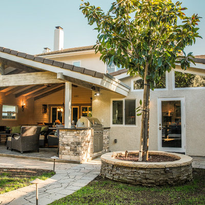 Mid-sized elegant backyard patio kitchen photo in Los Angeles with a roof extension and decking