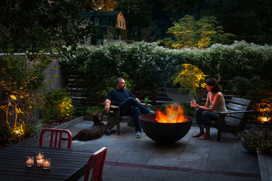 Example of a trendy side yard patio design in Philadelphia with a fire pit and no cover