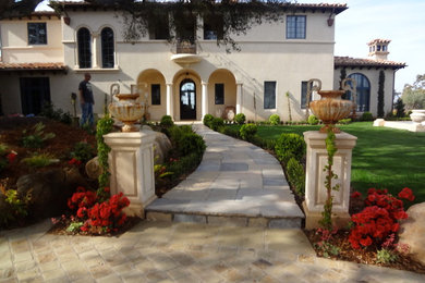 Design ideas for a large mediterranean front patio in Santa Barbara with natural stone paving.
