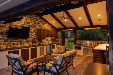 Mid-sized mountain style backyard concrete paver patio kitchen photo in Philadelphia with a roof extension