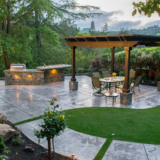 Ispirazione per un patio o portico mediterraneo di medie dimensioni e dietro casa con cemento stampato e una pergola