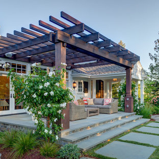 Foto di un patio o portico country dietro casa con una pergola