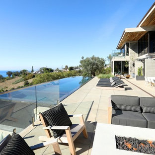 Ispirazione per un ampio patio o portico design dietro casa con un caminetto, pavimentazioni in cemento e nessuna copertura