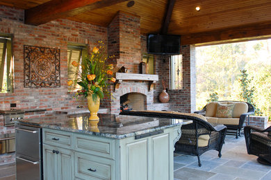 Example of a large tuscan backyard brick patio kitchen design in New Orleans with a gazebo