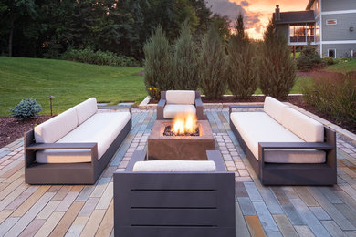 Example of a mid-sized trendy backyard concrete paver patio design in Minneapolis with a fire pit and no cover