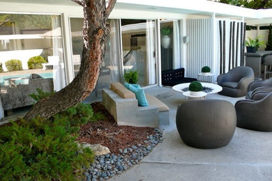 Foto de patio ecléctico de tamaño medio sin cubierta en patio trasero con brasero y losas de hormigón