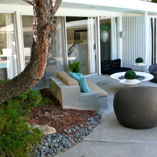 Foto di un patio o portico boho chic di medie dimensioni e dietro casa con un focolare, lastre di cemento e nessuna copertura