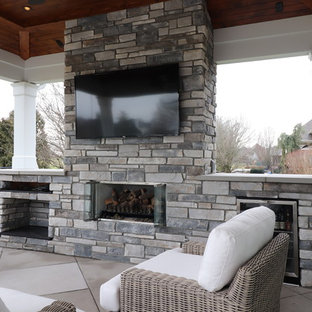 Large elegant backyard concrete paver patio photo in Louisville with a fireplace and a roof extension