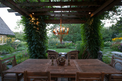 Пример оригинального дизайна: большая пергола во дворе частного дома на заднем дворе в классическом стиле с вертикальным садом и покрытием из каменной брусчатки