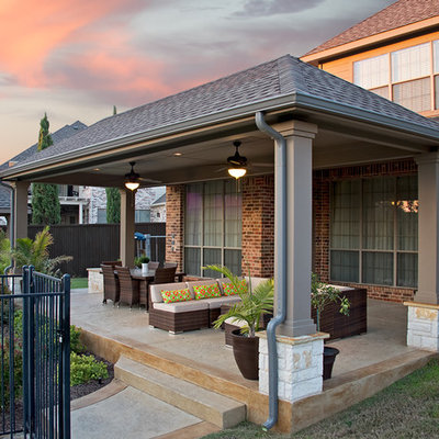 Mid-sized trendy backyard stamped concrete patio photo in Dallas with a roof extension