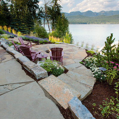 Mid-sized trendy backyard stone patio photo in Other with a fire pit and no cover