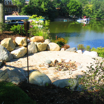 Lakeside rustic fire pit with a boulder seating wall