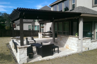 Imagen de patio de tamaño medio en patio trasero con cocina exterior, adoquines de piedra natural y pérgola