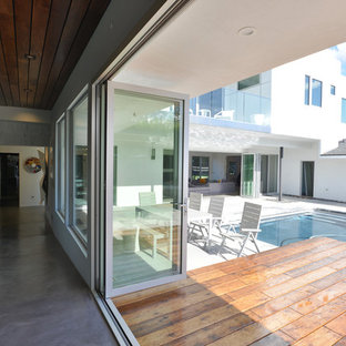 Inspiration for a large modern backyard patio remodel in Los Angeles with decking and a roof extension