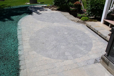 This is an example of a medium sized back patio in New York with concrete paving.