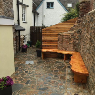 Idee per un piccolo patio o portico moderno in cortile con pavimentazioni in pietra naturale e nessuna copertura