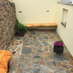 Esempio di un piccolo patio o portico moderno in cortile con pavimentazioni in pietra naturale e nessuna copertura