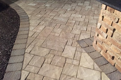 Example of a large transitional backyard concrete paver patio kitchen design in Cleveland