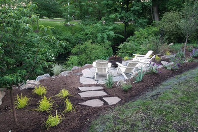 Example of a mid-sized classic side yard stone patio design in New York with a fire pit