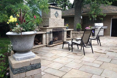 Modelo de patio clásico sin cubierta en patio trasero con brasero y adoquines de piedra natural