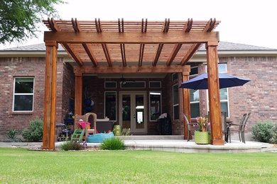 Patio - mid-sized contemporary backyard stone patio idea in Austin with a pergola
