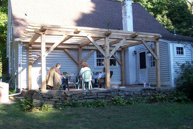 Idée de décoration pour une terrasse arrière champêtre avec des pavés en brique et une pergola.