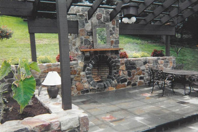 Diseño de patio de tamaño medio en patio trasero y anexo de casas con adoquines de piedra natural