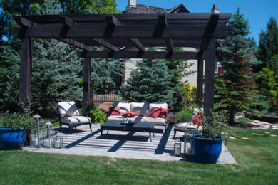 This is an example of a medium sized back patio in Boise with concrete paving and an awning.