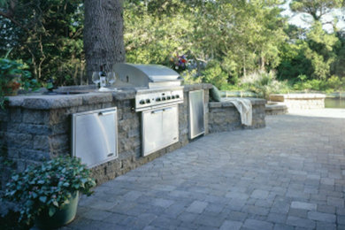 Example of a mid-sized classic backyard concrete paver patio kitchen design in Other with no cover