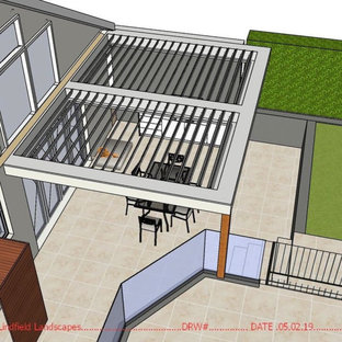 Esempio di un patio o portico shabby-chic style di medie dimensioni e dietro casa con pavimentazioni in pietra naturale e una pergola